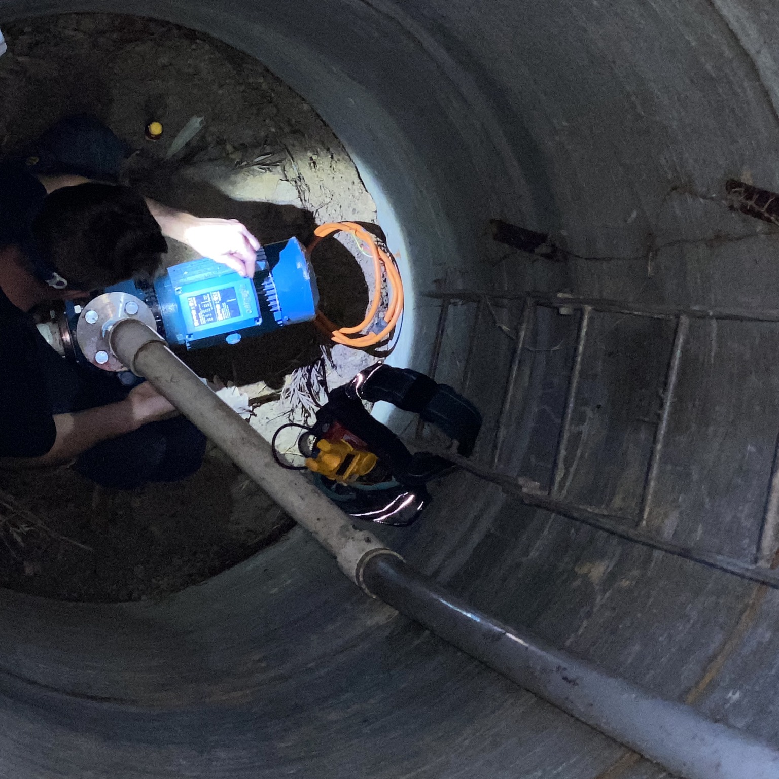 Looking down a bore chamber at James connecting a blue pump control unit